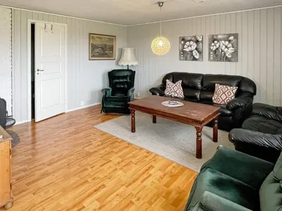 a living room with a leather couch and a coffee table at 6 person holiday home in Farstad-By Traum in Farstad