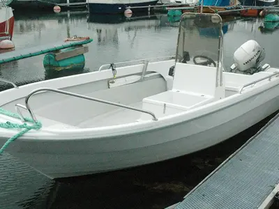 a white boat tied to a dock in the water at 6 person holiday home in Farstad-By Traum in Farstad