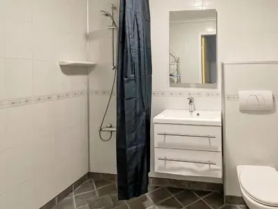 a bathroom with a sink and a toilet and a mirror at 6 person holiday home in Farstad-By Traum in Farstad