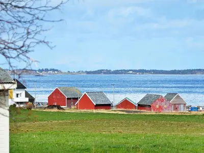 a group of red houses next to a body of water at 11 person holiday home in Fjørtoft-By Traum in Fjørtoft