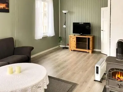 a living room with a couch and a television and a fireplace at 6 person holiday home in Svelgen-By Traum in Sørgulen