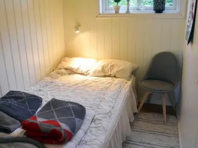 a small bedroom with a bed and a chair at 6 person holiday home in Åram-By Traum in Sandvik