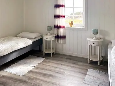 a bedroom with two tables and a bed and a window at 6 person holiday home in Storfosna-By Traum in Sletta