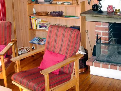 a living room with a chair and a fireplace at 6 person holiday home in NESBYEN-By Traum in Nesbyen
