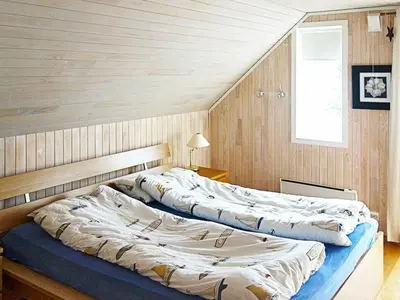 two large beds in a room with wood paneling at 9 person holiday home in GURSKØY-By Traum in Kjellsund