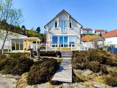 a house with a wooden walkway in front of it at 9 person holiday home in GURSKØY-By Traum in Kjellsund
