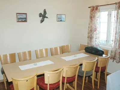 a dining room table with chairs and a suitcase on the wall at 4 person holiday home in Lauvstad-By Traum in Lauvstad