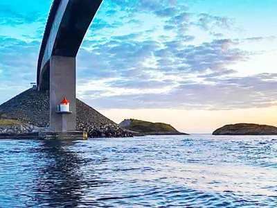a bridge over the water with a small house under it at 11 person holiday home in VEVANG-By Traum in Vevang