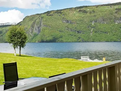 a view of a lake with a bench and a tree at 4 person holiday home in Utvik-By Traum in Reed