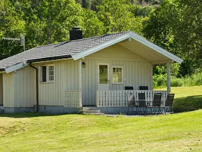 a small house with a table and chairs in a yard at 4 person holiday home in Utvik-By Traum in Reed