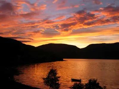 a sunset over a lake with a boat on it at 4 person holiday home in Utvik-By Traum in Reed