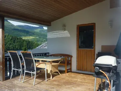 a patio with a table and chairs on a balcony at 10 person holiday home in Bygstad-By Traum in Bygstad