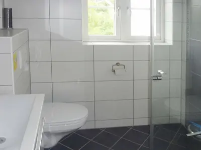 a white bathroom with a toilet and a window at 10 person holiday home in Bygstad-By Traum in Bygstad