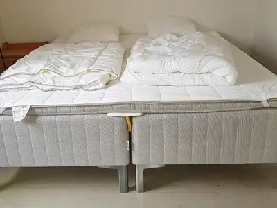 a bed with white sheets and pillows on it at 10 person holiday home in Bygstad-By Traum in Bygstad