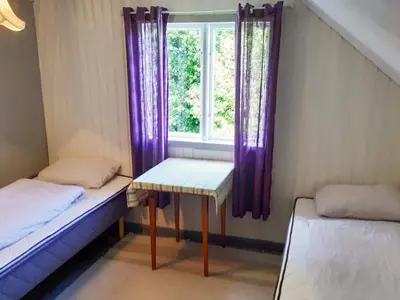 a room with two beds and a window with purple curtains at 8 person holiday home in Åfarnes-By Traum in Årset