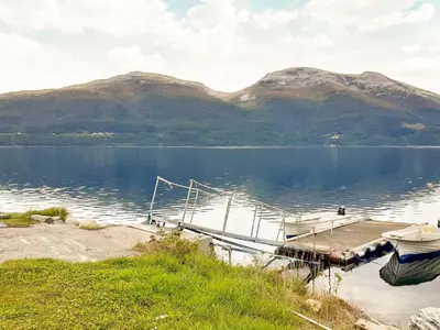 a boat is docked at a dock on a lake at 8 person holiday home in Åfarnes-By Traum in Årset