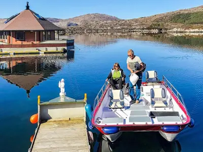 a man and a woman on a boat at a dock at 6 person holiday home in Kalvåg-By Traum in Kalvåg
