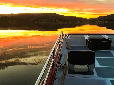 a boat on the water with a sunset in the background at 8 person holiday home in Kalvåg-By Traum in Kalvåg