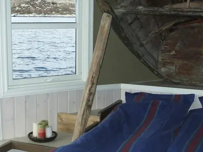 a wooden chair next to a window in a room at 8 person holiday home in Kalvåg-By Traum in Kalvåg