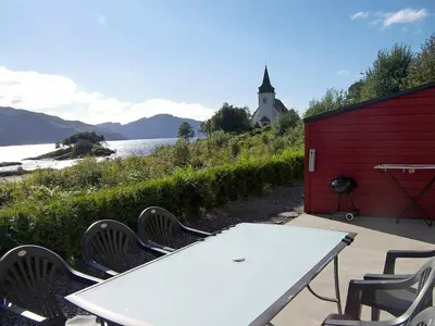 a picnic table and chairs next to a body of water at 6 person holiday home in Sørbøvåg-By Traum in Sørbø