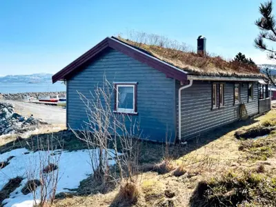 a blue house with a grass roof at 6 person holiday home in Storfosna-By Traum in Sletta
