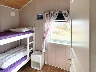 a small room with two bunk beds and a window at 6 person holiday home in Storfosna-By Traum in Sletta