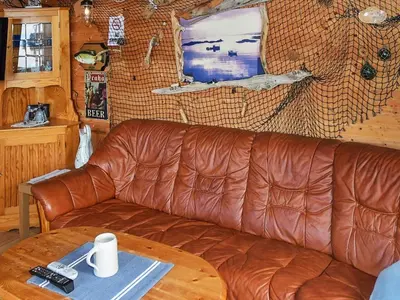 a brown leather couch in a living room with a table at 6 person holiday home in Oksvoll-By Traum in Oksvoll