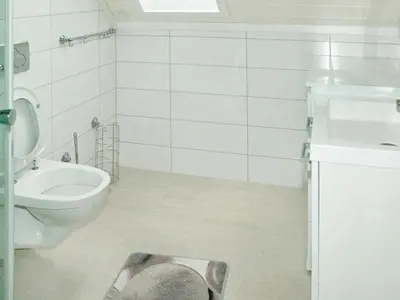 a bathroom with a toilet and a sink and a magazine on the floor at 6 person holiday home in Gursken-By Traum in Larsnes
