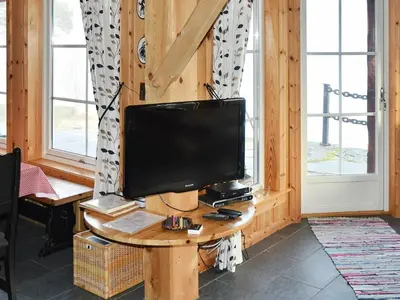 a television sitting on a table in a room withwindows at 7 person holiday home in Blaksæter-By Traum in Sølberg