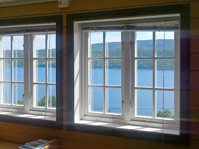 two windows in a room with a view of the water at 10 person holiday home in Follafoss-By Traum in Vølset