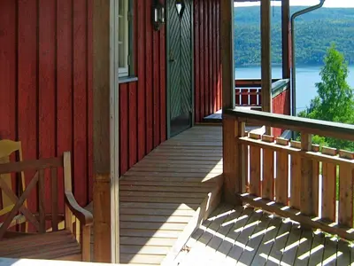 a wooden porch of a house with a view of the water at 10 person holiday home in Follafoss-By Traum in Vølset