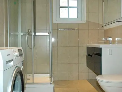 a bathroom with a shower and a washing machine at 8 person holiday home in VEVANG-By Traum in Vevang