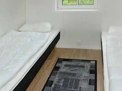 a room with two beds and a window and a rug at 8 person holiday home in VEVANG-By Traum in Vevang