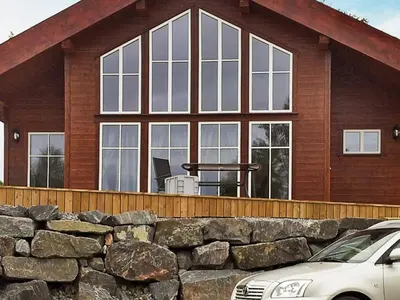a house with windows and a stone wall at 8 person holiday home in VEVANG-By Traum in Vevang