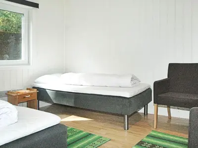 a room with two beds and a chair in it at 5 person holiday home in VEVANG-By Traum in Vevang