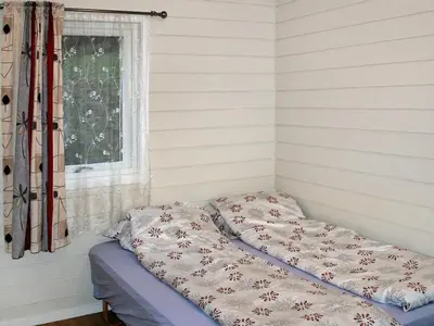 a bed in a corner of a room with a window at 7 person holiday home in Selje-By Traum in Selje