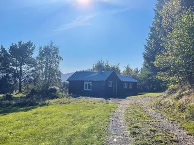 a blue house in a field next to a dirt road at 3 person holiday home in Frei-By Traum in Frei