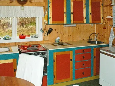 a kitchen with red and blue cabinets and a sink at 3 person holiday home in Frei-By Traum in Frei