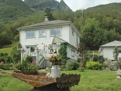 a large white house with a garden in front of it at 11 person holiday home in Syvde in Myklebost