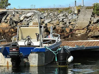 a blue and white boat tied to a dock at 12 person holiday home in Kvenvær in Kvenvær