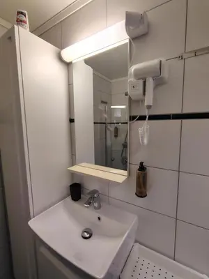a bathroom with a sink and a mirror at Oppheim Holiday Apartment in Øyjordi