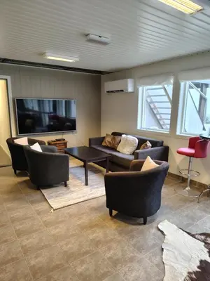 a living room with couches and a table and a tv at Oppheim Holiday Apartment in Øyjordi