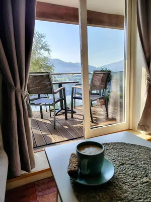 a cup of coffee on a table in front of a window at Oppheim Holiday Apartment in Øyjordi