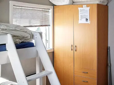 a bunk bed with a ladder next to a wooden cabinet at 6 person holiday home in Øvre Årdal in Øvre Årdal