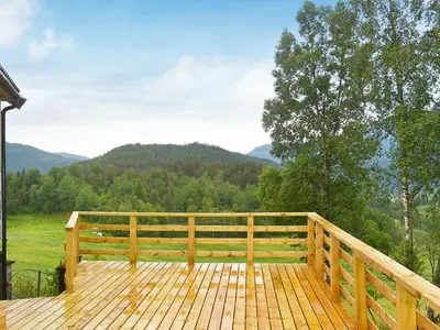 a wooden deck with a view of the mountains at 10 person holiday home in Bygstad in Bygstad