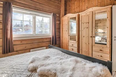 a bedroom with a bed in a wooden room at Trysilfjellet Nord 356 A and B in Trysil