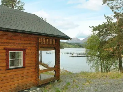 a log cabin with a view of a lake at 5 person holiday home in VÅGLAND in Bårdset