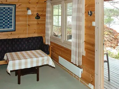 a room with a bench and a window in a cabin at 5 person holiday home in VÅGLAND in Bårdset