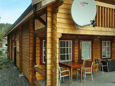 a log cabin with a table and a mirror at 5 person holiday home in VÅGLAND in Bårdset