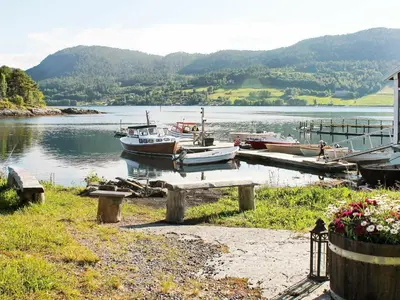 a group of boats docked at a dock on a lake at 5 person holiday home in VÅGLAND in Bårdset